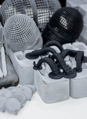 Birçok model 3D yazıcıda basıldı. Gri ve siyah nesneler 3D yazıcı.
