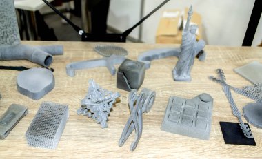 Birçok model 3D yazıcıda basıldı. Gri ve siyah nesneler 3D yazıcı.