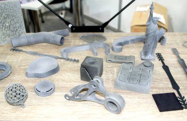 Birçok model 3D yazıcıda basıldı. Gri ve siyah nesneler 3D yazıcı.