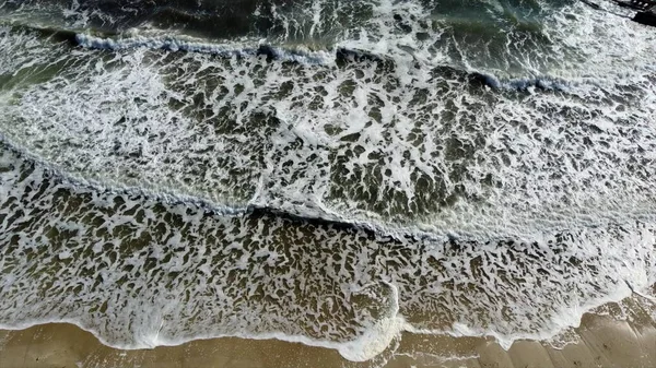공중 무인기에서는 하얀 거품이 덮인 모래사장의 아름다운 바 다 물결을 넘는 비행을 바라본다 — 스톡 사진
