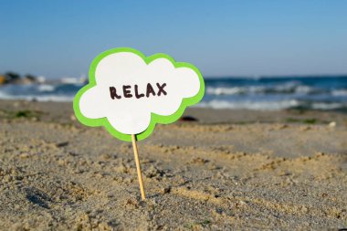 Kağıttan konuşma baloncuğu olan küçük bir çubuk Kumsalda duruyor rahatla