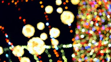Büyük bir yılbaşı ağacı. Parlak renkli çelenkler ve gece aydınlatmasıyla süslenmiş. Yanıp sönen ışıkları olan Noel ağacı. Arka plan bulanık. Yılbaşı ve Noel tatili