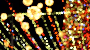 Büyük bir yılbaşı ağacı. Parlak renkli çelenkler ve gece aydınlatmasıyla süslenmiş. Yanıp sönen ışıkları olan Noel ağacı. Arka plan bulanık. Yılbaşı ve Noel tatili