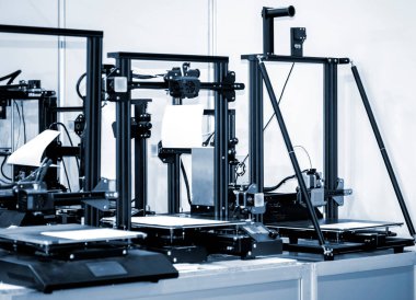 Masada birkaç tane boş 3D yazıcı var. Boş masaüstü olan 3D yazıcı. Yazıcı 3dprinter açılıyor. İlerici katkı sağlayan modern 3D baskı teknolojisi. Yüksek hassasiyetli 3D baskı teknolojileri