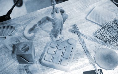 3D yazıcıda birçok farklı model basıldı. Plastikten yapılmış 3 boyutlu yazıcıya basılmış gri ve siyah nesneler. Bir sürü 3D baskı modeli. Masadaki 3D yazıcı tarafından yapılan çeşitli şekillerin prototipleri.