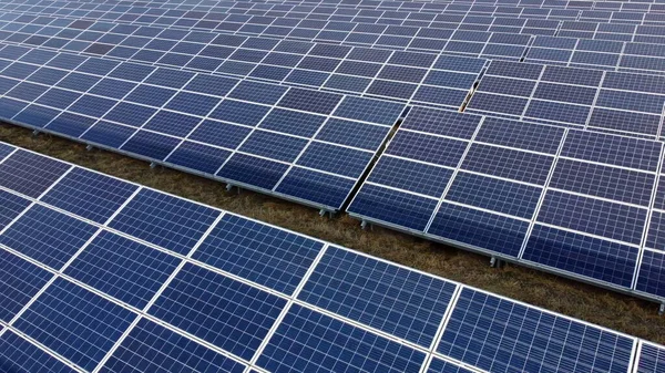 Aerial drone view flight over solar power station panels. Aerial top view of solar farm. Green energy, electrical innovation. Renewable Energy. Industrial Solar Energy Farm producing solar power.