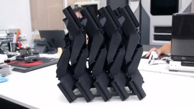 Laboratuvar ofisindeki 3D yazıcıya siyah model basılmış. Plastik kapaktan 3D yazıcıya basılmış nesne. 3D yazıcıda yapılmış bir prototip. Yeni modern baskı teknolojisi kavramı. Çoklu Jet Füzyonu