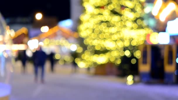 Wazige Achtergrond Kerstboom Versierde Gloeiende Lichten Gebouw Wazige Silhouetten Van — Stockvideo