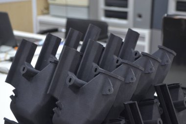Laboratuvar ofisindeki 3D yazıcıya siyah model basılmış. Plastik kapaktan 3D yazıcıya basılmış nesne. 3D yazıcıda yapılmış bir prototip. Yeni modern baskı teknolojisi kavramı. Çoklu Jet Füzyonu