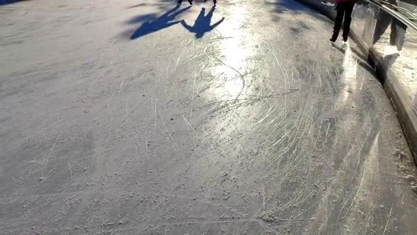 在阳光明媚的冬日 人们在城市露天溜冰场上滑冰 人们在冰场上滑冰 阳光溜冰场 寒假活动休闲活动 — 图库视频影像