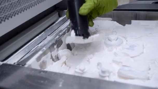 一个正在使用真空吸尘器的人 从3D打印机内的3D打印机上打印的模型上清除聚酰胺的白色粉末 工业用粉末3D打印机上打印的清洁用品 — 图库视频影像