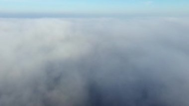 Sis üzerinde uçan insansız hava aracı. Güneşli bir günde mavi gökyüzünde beyaz pofuduk sis ve bulutlar arasında uçmak. Doğal soyut arka plan. Hava bulutlu. Atmosfer. Üst görünüm sis hareketi. Zaman Uygulaması.