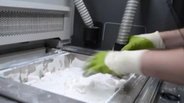 Mühendis ya da sanatçı tasarımcı 3 boyutlu parçalar basıyor ve toz 3 boyutlu baskıdan modelleri şekillendiriyor. Heykel yapmak, yaratmak, yapmak. Yeni 3D baskı teknolojileri. Çoklu Jet Füzyonu. Gelişmiş katkı teknolojisi kullanımda.