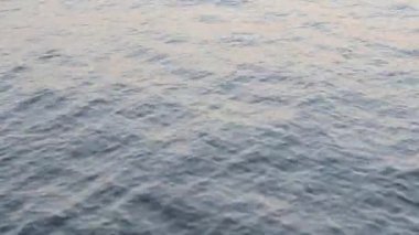 Soyut doğal arkaplan. Akşamları ve sabahları okyanus gölü nehrinin su yüzeyinde küçük dalgalar dalgalanır. Su ışığı yansıması. Su kaynakları. Çevre arkaplanı. Kusursuz Döngü