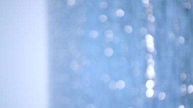 Blurred background. Sea, white sun reflections and blue sky on hot sunny summer day. Sun shines on sea surface water on seacoast. Beautiful abstract natural background. Seamless Looping Vertical video