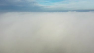 Sis üzerinde uçan insansız hava aracı. Güneşli bir günde mavi gökyüzünde beyaz pofuduk sis ve bulutlar arasında uçmak. Doğal soyut arka plan. Hava bulutlu. Atmosfer. Üst görünüm sis hareketi. Zaman Uygulaması.