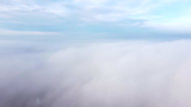 Sis üzerinde uçan insansız hava aracı. Güneşli bir günde mavi gökyüzünde beyaz pofuduk sis ve bulutlar arasında uçmak. Doğal soyut arka plan. Hava bulutlu. Atmosfer. Üst görünüm sis hareketi. Zaman Uygulaması.