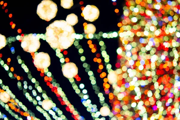 明るい多色のガーランドと夜の照明で飾られた大きな新年のクリスマスツリー 明かりが点滅するクリスマスツリー 背景がぼやけている 新年とクリスマスの休日 — ストック写真