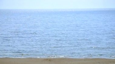 Background. Sea, sea waves, sandy beach, sky, white sun glare spots on sea water in summer sunny day. Wildlife seascape, nature, sea coast, seaside seashore. Summer abstract natural background