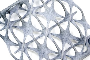 Model printed on 3D printer isolated on white background. Object details printed on 3D printer from plastic close-up. Prototype of shape made by 3d printer. Concept new modern printing technology