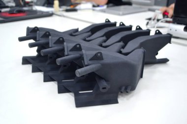 Laboratuvar ofisindeki 3D yazıcıya siyah model basılmış. Plastik kapaktan 3D yazıcıya basılmış nesne. 3D yazıcıda yapılmış bir prototip. Yeni modern baskı teknolojisi kavramı. Çoklu Jet Füzyonu