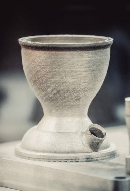 Adam metal 3D yazıcıya basılı nesne tutuyor. Nesne lazer sindirim makinesine basılmış. Metal tozundan modern 3D yazıcı baskısı. İlerici katkı maddesi DMLS, SLM, SLS 3D yazdırma teknolojisi