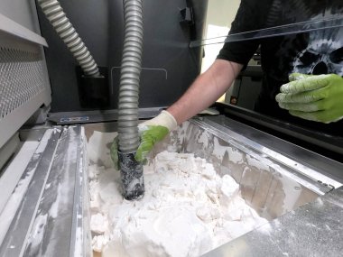 Engineer or artist designer printing 3D parts and shaping models from dust 3D print. Sculpting, creating, making. New 3D printing technologies. Multi Jet Fusion. Advanced additive technology in use.