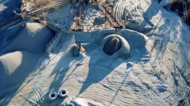 Crushing plant in granite quarry top view. Aerial flight over crusher in granite quarry. Stone crushing. Industrial production of gravel. Gravel conveyor view above. Cone type rock crusher,