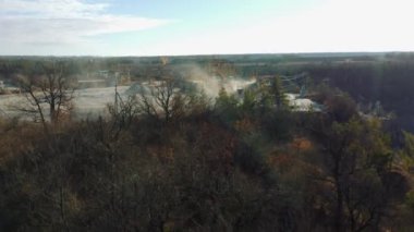 Crushing plant in granite quarry top view. Aerial flight over crusher in granite quarry. Stone crushing. Industrial production of gravel. Gravel conveyor view above. Cone type rock crusher,