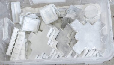 Detail objects printed on powder 3D printer and covered white polyamide powder close-up. Technology Multi Jet Fusion MJF. 3D prototype models created by new additive progressive 3d printing technology