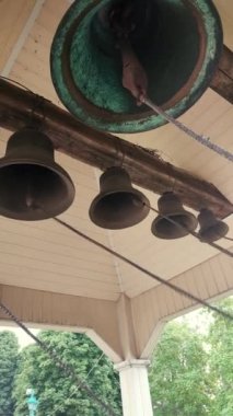 Ring the bells. Ringing church bells. Bell tower inside. Church bells ringing. Chime. Ding-dong. Bells bottom view. Ringing. Vertical video