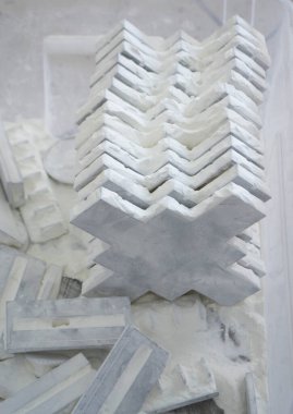Detail objects printed on powder 3D printer and covered white polyamide powder close-up. Technology Multi Jet Fusion MJF. 3D prototype models created by new additive progressive 3d printing technology