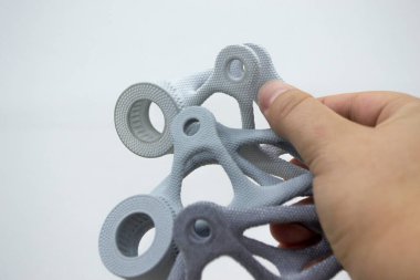 Plastik maketi elinde tutan kişi, biyo-uyumlu poliyamid tozunun 3D yazıcısına basılmış. Çoklu Jet Füzyon MJF. Yeni modern endüstriyel 3D baskı teknolojisi. İlerici katkı teknolojileri