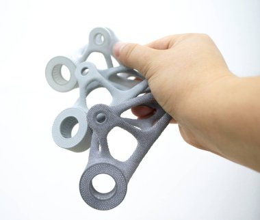 Plastik maketi elinde tutan kişi, biyo-uyumlu poliyamid tozunun 3D yazıcısına basılmış. Çoklu Jet Füzyon MJF. Yeni modern endüstriyel 3D baskı teknolojisi. İlerici katkı teknolojileri