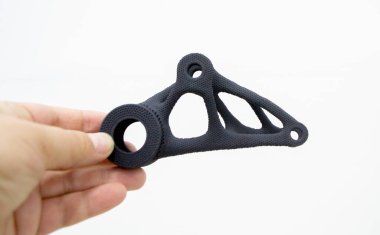 Pudra 3D yazıcıya yüksek hızlı sindirme yöntemiyle baruttan basılmış plastik model tutan kişi. Çoklu Jet Füzyon MJF. Yeni modern 3D baskı teknolojisi. İlerici katkı teknolojileri