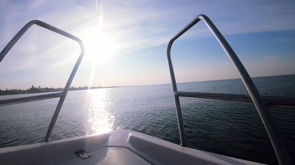 Seascape, view of sea waves with sun reflection from prow of motorboat. Boat jumping on waves on sunny summer day. Yacht motor boat sailing fast at sea horizon. Extreme sport entertainment background