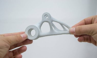 Pudra 3D yazıcıya yüksek hızlı sindirme yöntemiyle baruttan basılmış plastik model tutan kişi. Çoklu Jet Füzyon MJF. Yeni modern 3D baskı teknolojisi. İlerici katkı teknolojileri