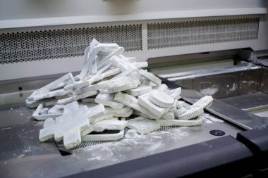 Detail objects printed on powder 3D printer and covered white polyamide powder close-up. Technology Multi Jet Fusion MJF. 3D prototype models created by new additive progressive 3d printing technology