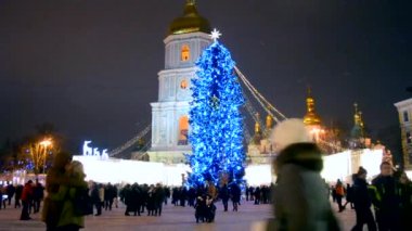 Kyiv, Ukraine January 5, 2019 - A large New Years Christmas tree stands on a square with a lot of people walking in the city center on a winter night. Walk, relax, celebrate in the city center