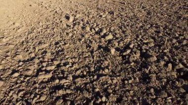 Flying over the plowed fields of black soil on sunny autumn day. Fields black soil close-up. Farming countryside rural. Digged agrarian agricultural earth fields. Plowed lands. Dug up ground farmlands