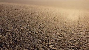 Flying over the plowed fields of black soil on sunny autumn day. Fields black soil close-up. Farming countryside rural. Digged agrarian agricultural earth fields. Plowed lands. Dug up ground farmlands
