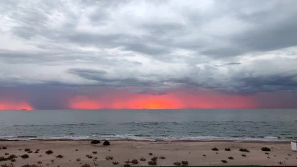 シースケープ 空の灰色の雨の雲 水平線上に雨 夜明け 海の波 砂浜の赤い線で覆われた 曇った曇りの海の天気 壮大なパノラマの風景 美しい自然背景 — ストック動画