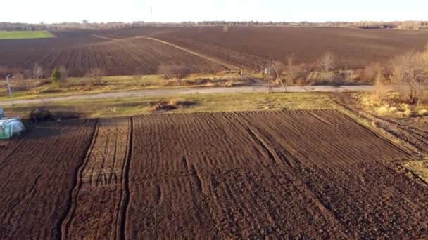 風景の田舎 晴れた秋の日に黒い土の土地の耕されたフィールド 空中ドローンビュー 農村部の農業 農業の大地のフィールドを掘ります 地上の農地を掘る — ストック動画