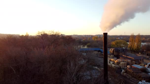 煙は秋の日没の夜明けに工場の煙突から来ています 煙突の近くから濃い煙を開く 空中ドローンビュー 製造業 環境汚染 温室効果 — ストック動画