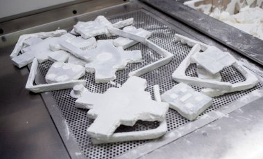 Detail objects printed on powder 3D printer and covered white polyamide powder close-up. Technology Multi Jet Fusion MJF. 3D prototype models created by new additive progressive 3d printing technology