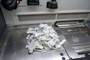 Detail objects printed on powder 3D printer and covered white polyamide powder close-up. Technology Multi Jet Fusion MJF. 3D prototype models created by new additive progressive 3d printing technology