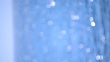 Blurred background. Sea, white sun reflections and blue sky on hot sunny summer day. Sun shines on sea surface water on seacoast. Beautiful abstract natural background. Seamless Looping Vertical video