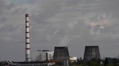 Timelapse Kompleksi güç santralleri bulutlu hava hızlı videosunda kapanıyor. Duman ve dipteki yağmurlu bulutların hızla hareket ettiği boru termal santralleri. Endüstri kirliliği