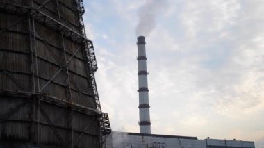 Büyük bir boru fabrikasından çıkan büyük bir duman sütunu. bacadan çıkan duman bulutlu havada yakınlaşıyor.