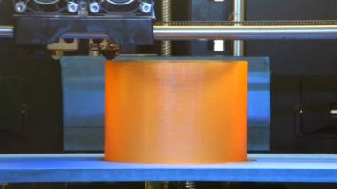 Yazıcı 3D, turuncu renkli yuvarlak bir nesne inşa ediyor. Modern katkı teknolojisi. 4. Sanayi Devrimi.